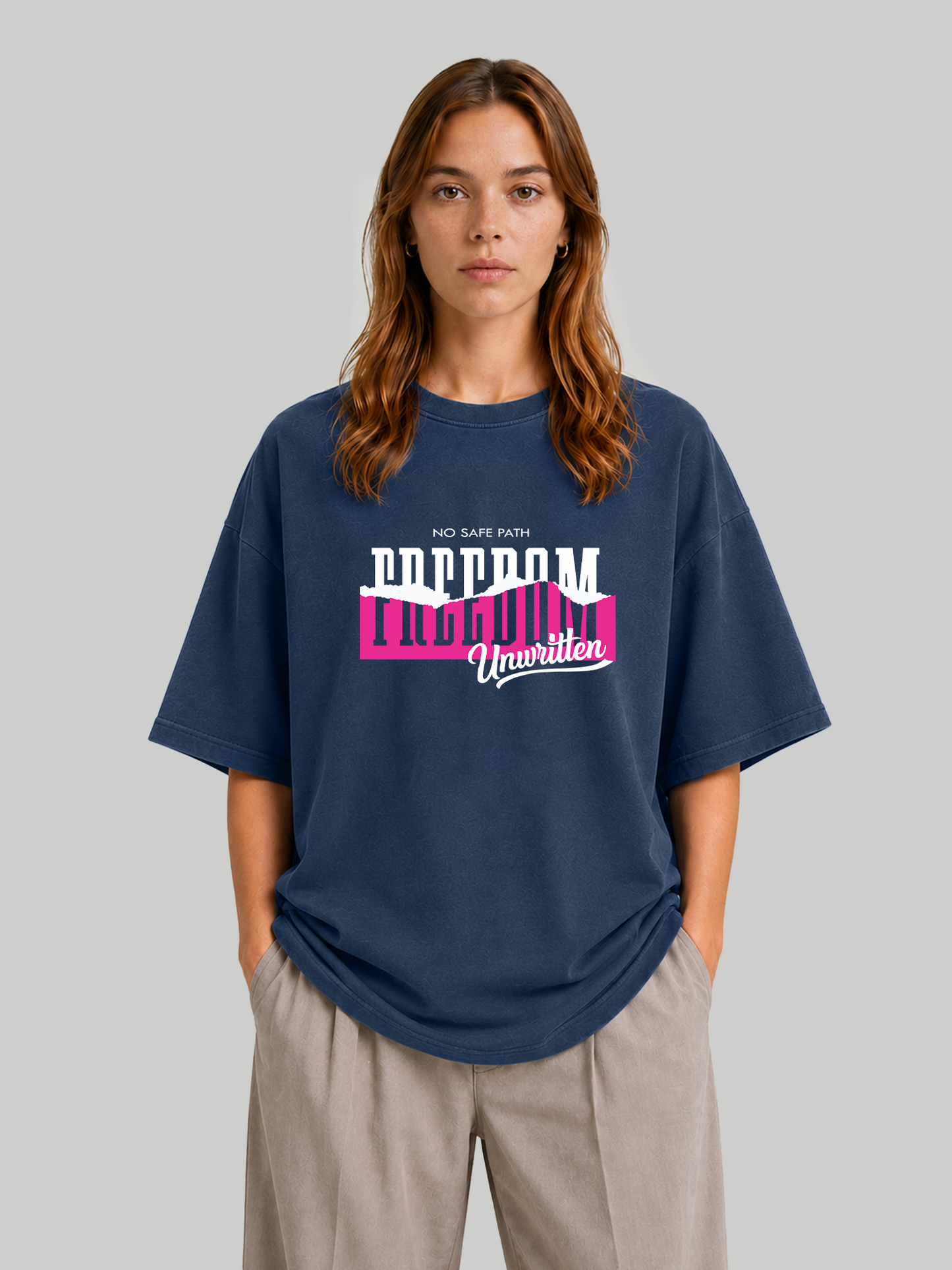 Women's oversized navy blue statement t-shirt with "No Safe Path – Freedom Unwritten" graphic, front-facing pose with hands in pockets.