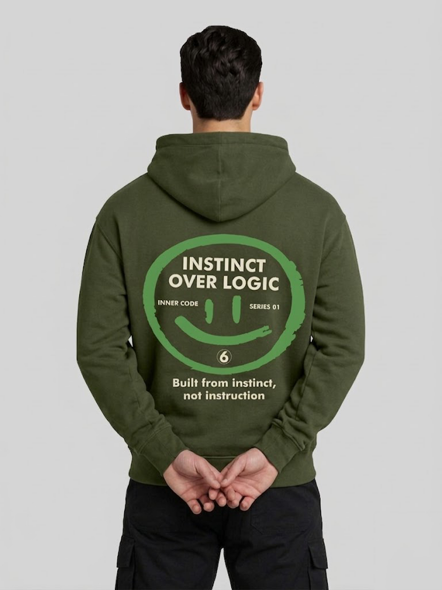 Instinct Over Logic military green hoodie for men back view with hands behind pose and graphic print