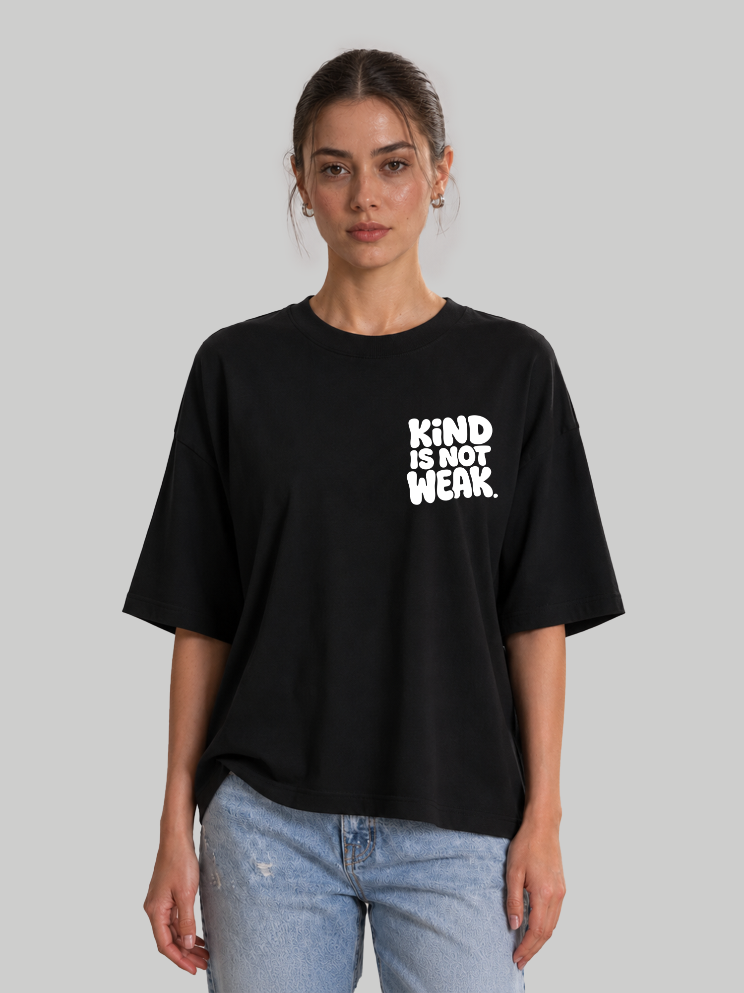 Women's oversized black relaxed-fit t-shirt featuring "Kind Is Not Weak" chest graphic, front view.