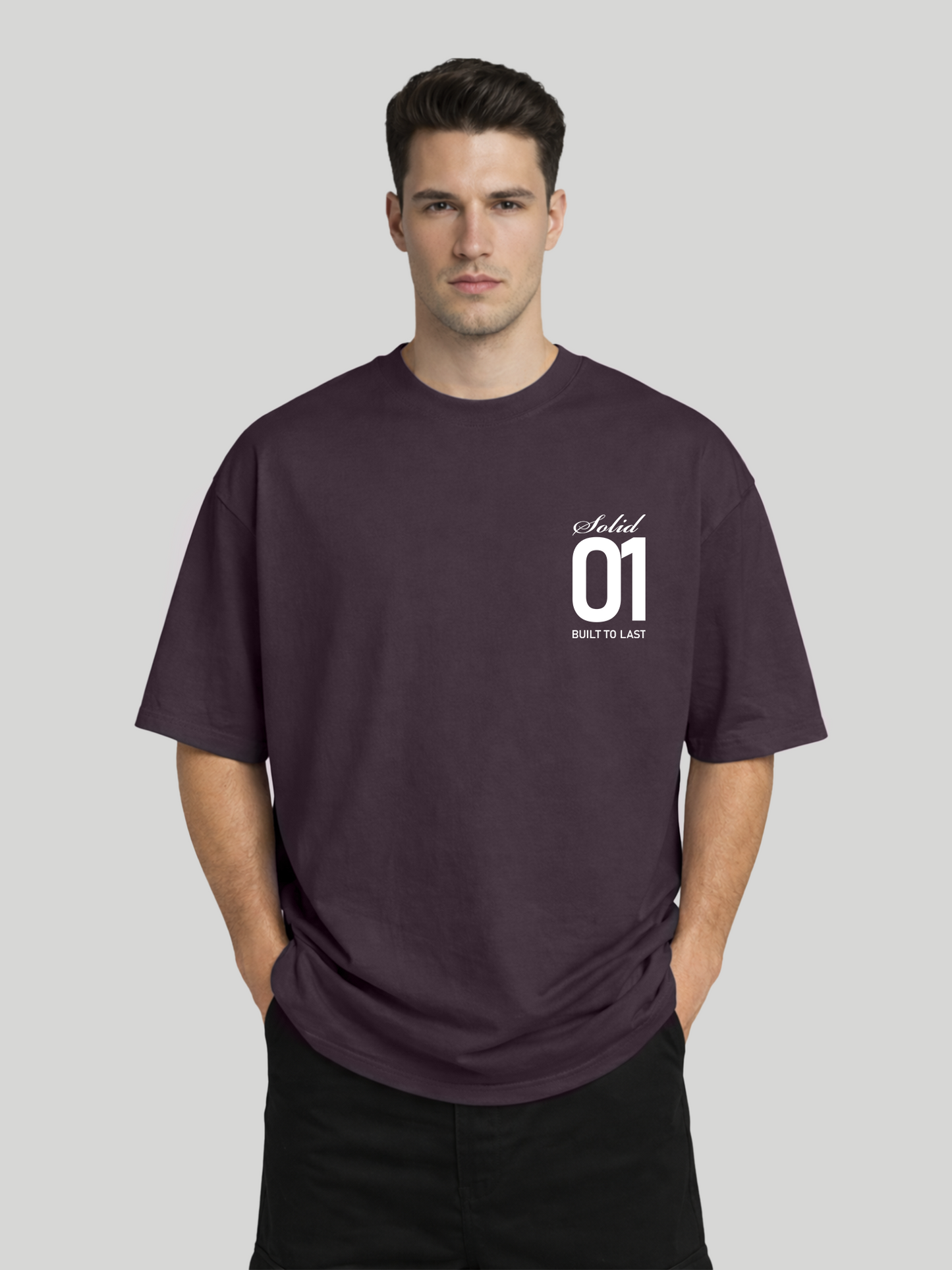 Man wearing plum oversized t-shirt with Solid 01 chest print in relaxed pose with hands in pockets