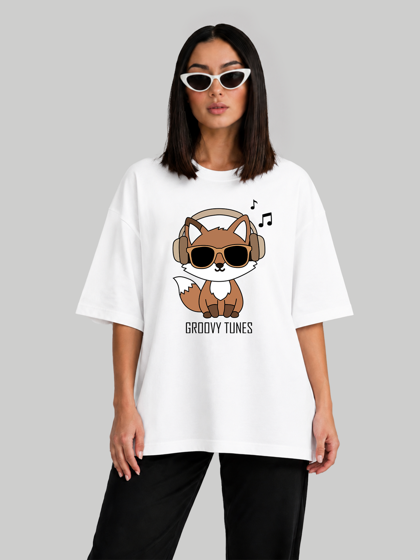 Women's oversized white graphic t-shirt with Groovy Tunes fox print, relaxed front-facing pose.
