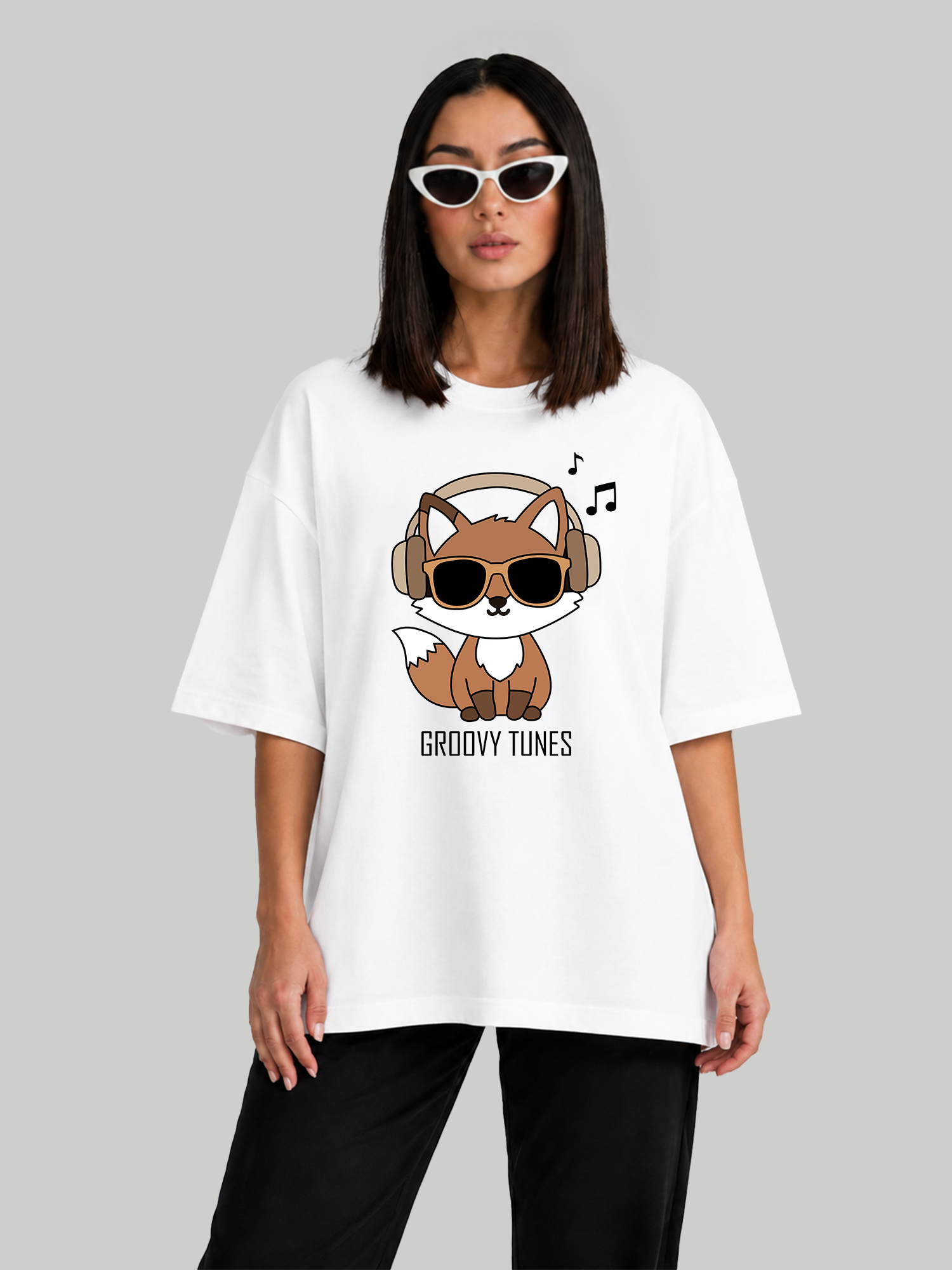 Women's oversized white graphic t-shirt with Groovy Tunes fox print, relaxed front-facing pose.