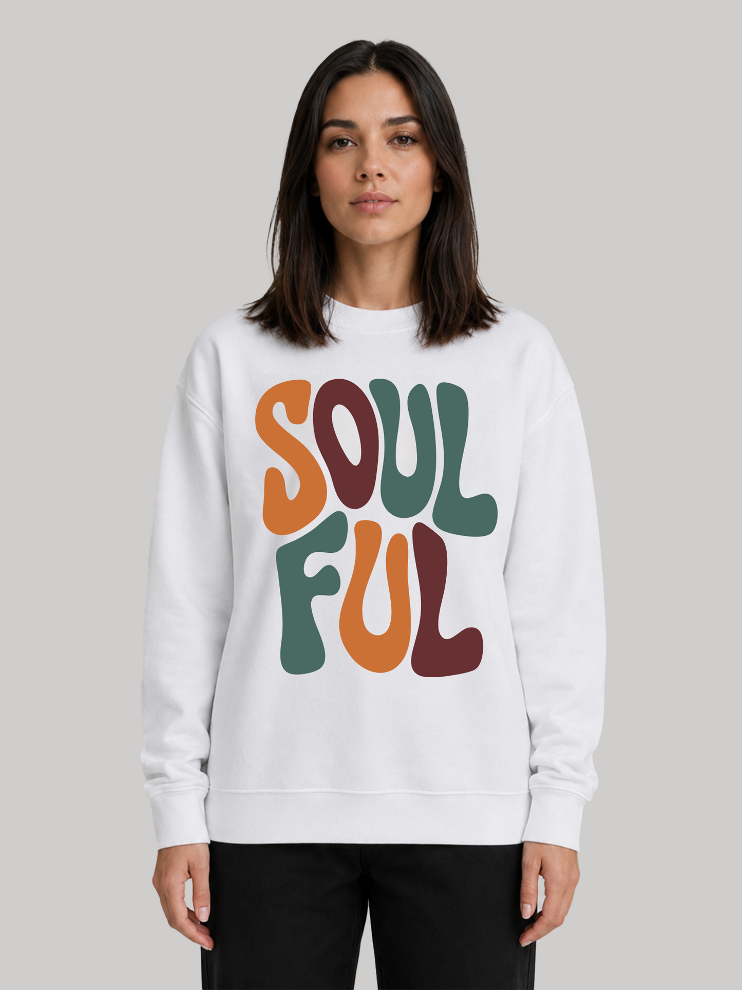 A straight front view of a female model wearing a white oversized crewneck sweatshirt with a large, multicolored retro "SOULFUL" print across the front.