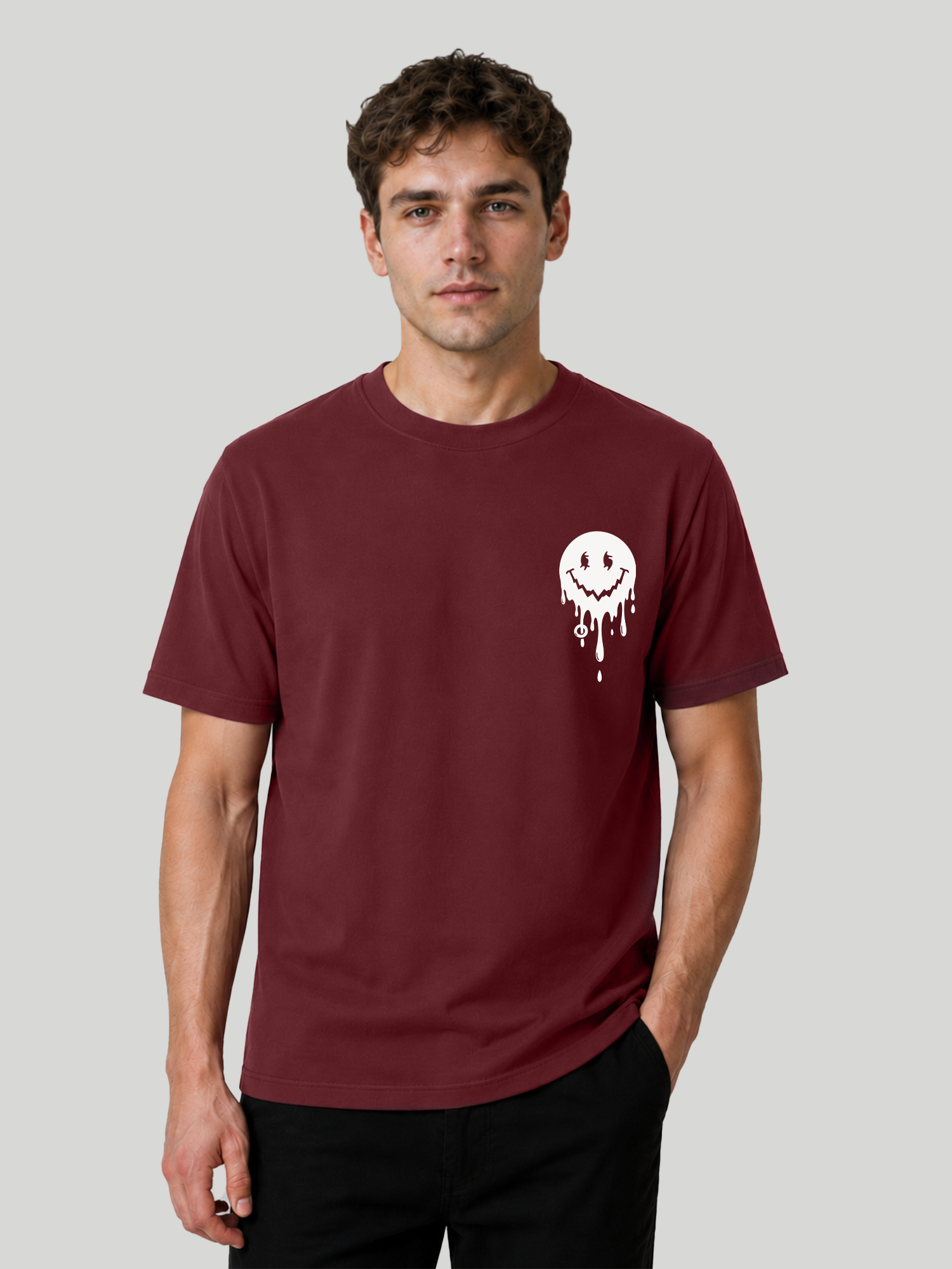 A front studio shot of a male model standing straight with one hand in his pocket, wearing a maroon premium cotton casual t-shirt with a custom graphic chest print.