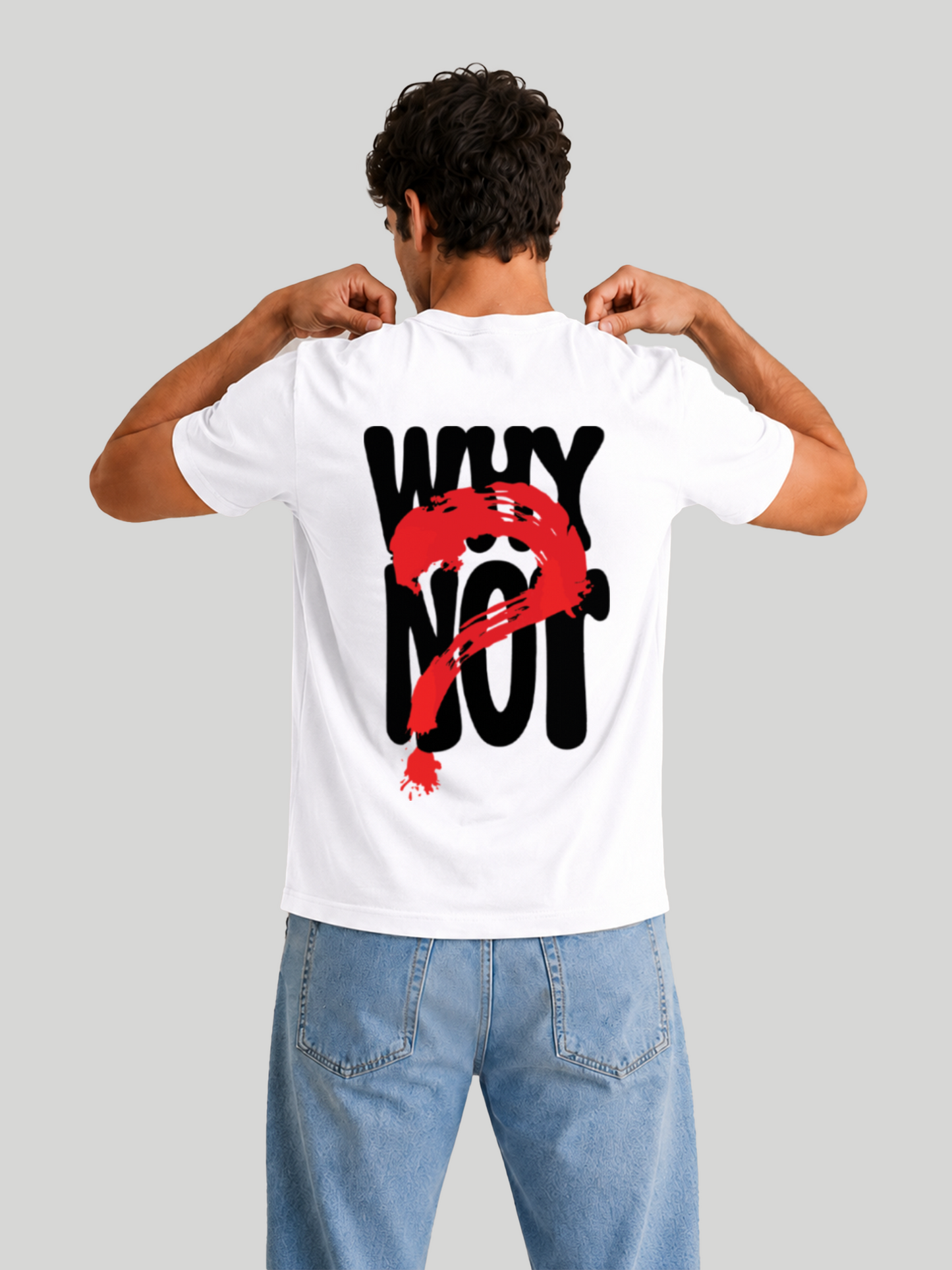 The back view of a male model wearing a white regular fit cotton t-shirt with a bold black typography print reading "WHY NOT" covered by a red brush-stroke question mark graphic, showcasing his hands pulling at the collar.