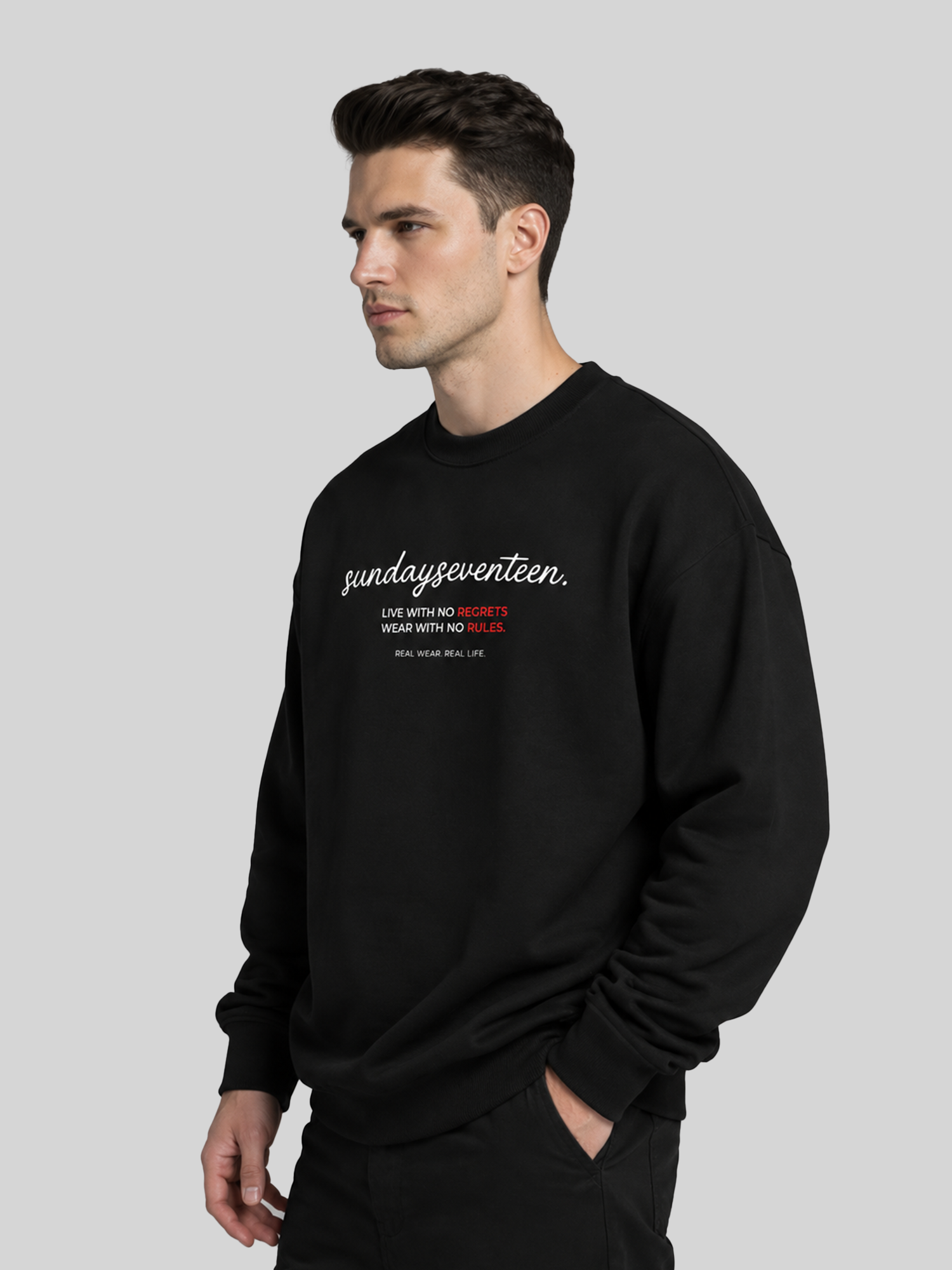 A side profile view of a male model wearing a black custom graphic sweatshirt with hands in his pocket, showing the fit and shoulder drape.