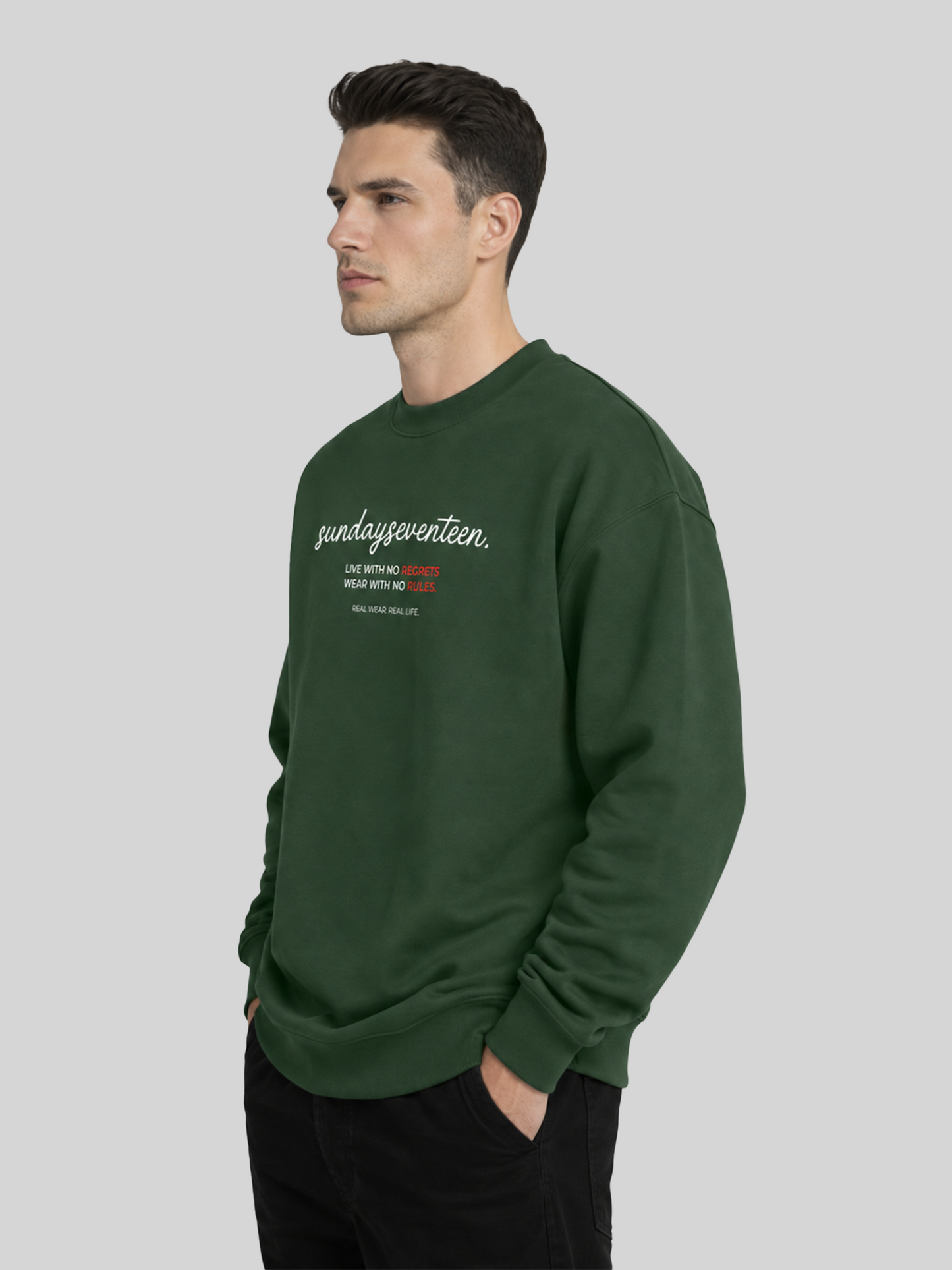 A side profile shot of a male model showcasing an olive green streetwear sweatshirt with chest typography print.
