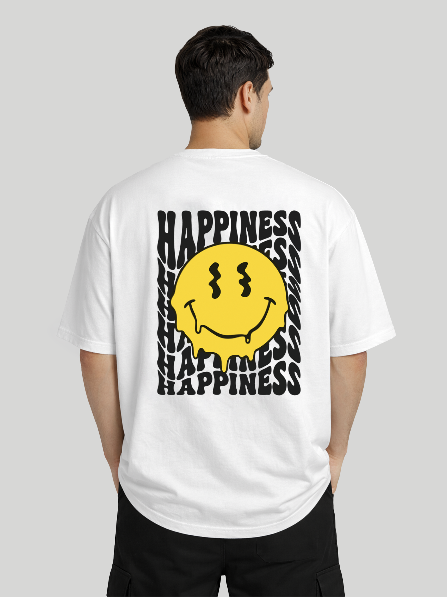 Back angled view of man wearing white oversized t-shirt with Happiness back graphic and yellow dripping smiley print