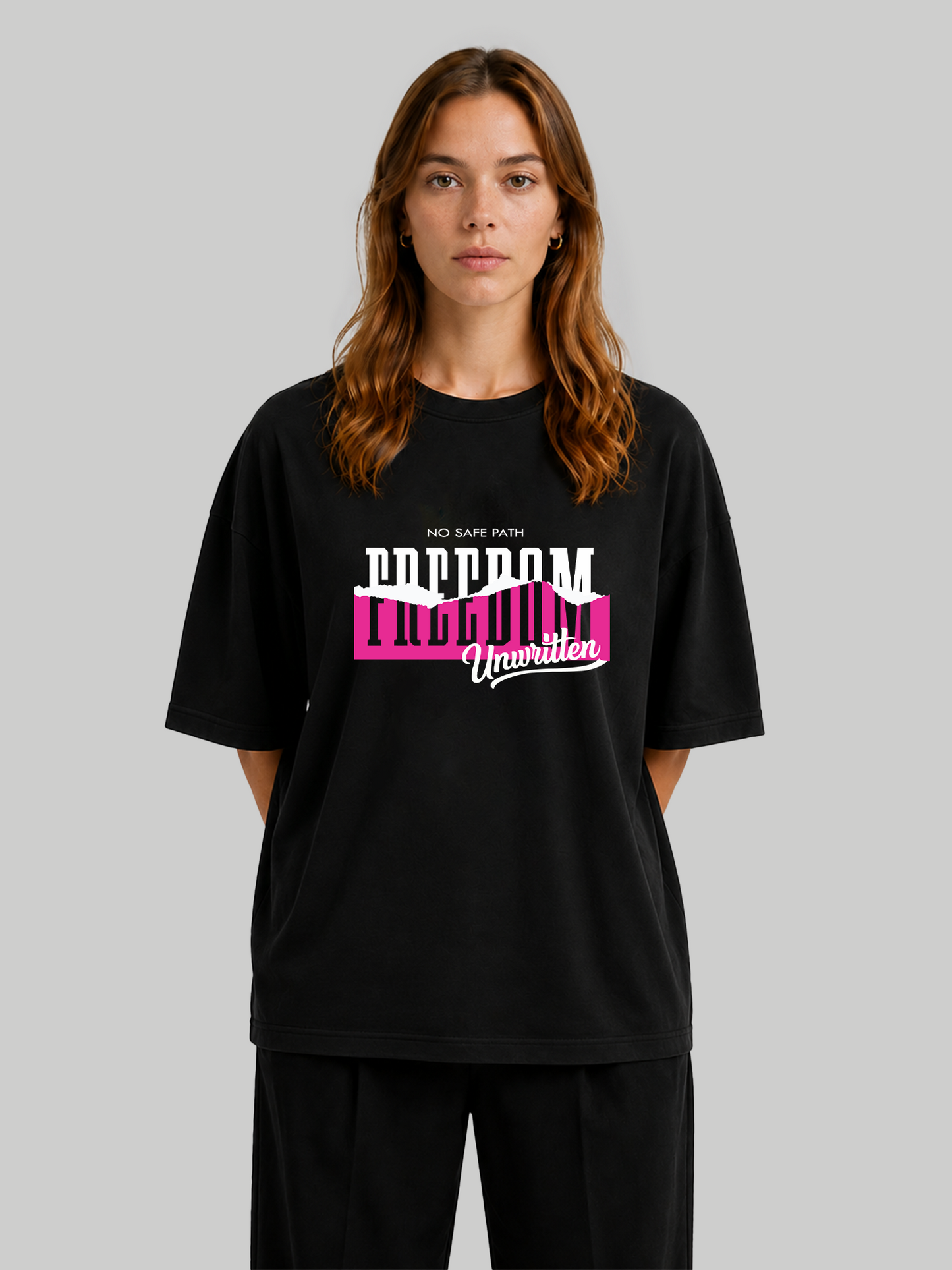 Women's oversized black graphic t-shirt featuring "No Safe Path – Freedom Unwritten" typography, front view with hands behind back.