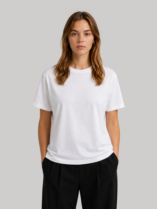 A front view of a female model posing with her hands in her pockets, showcasing the clean drape of a basic white regular fit half-sleeve t-shirt.