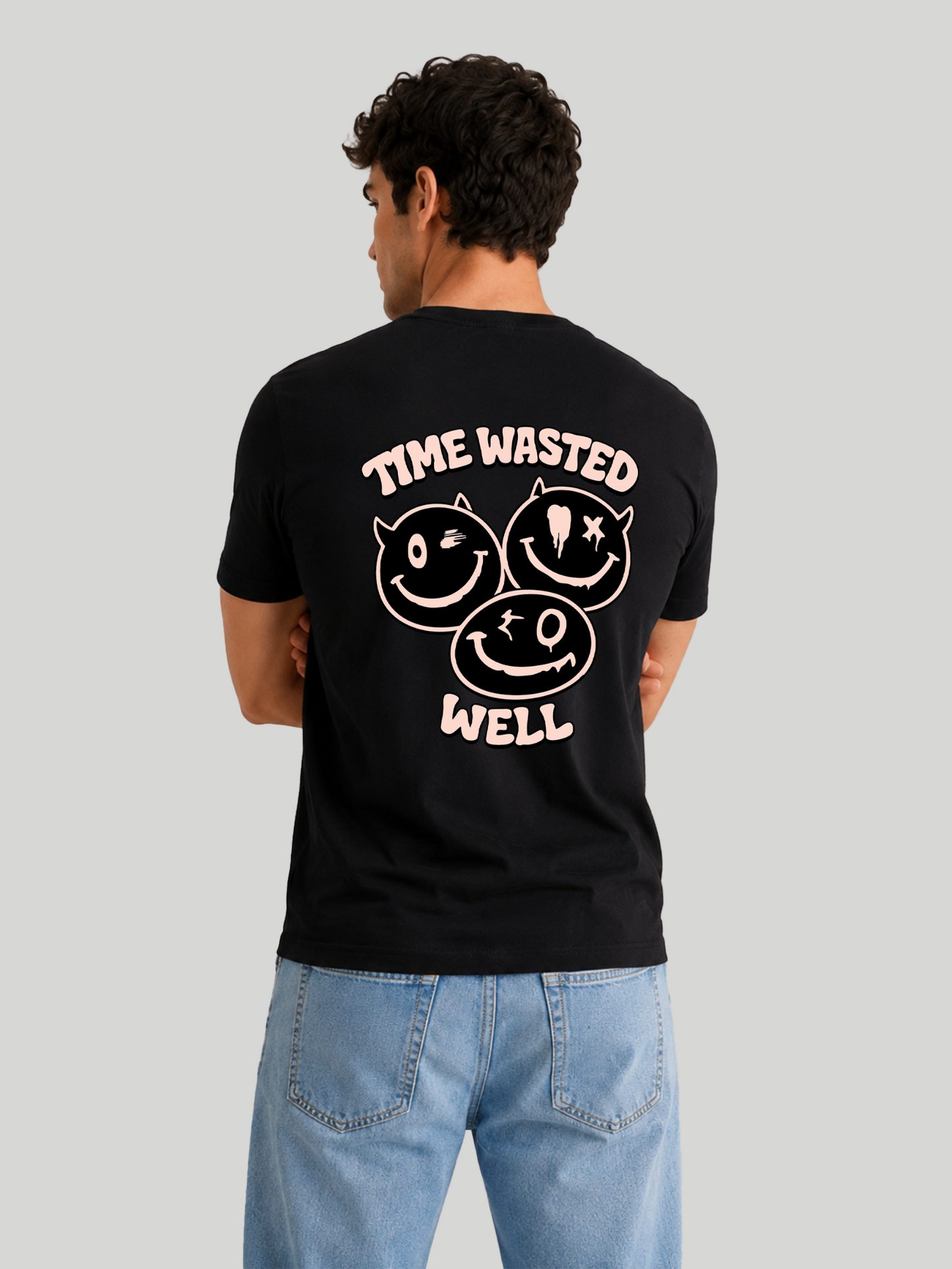 A back view of a male model standing with his arms crossed, highlighting the shoulder drape and fabric structure of a black custom printed streetwear t-shirt.