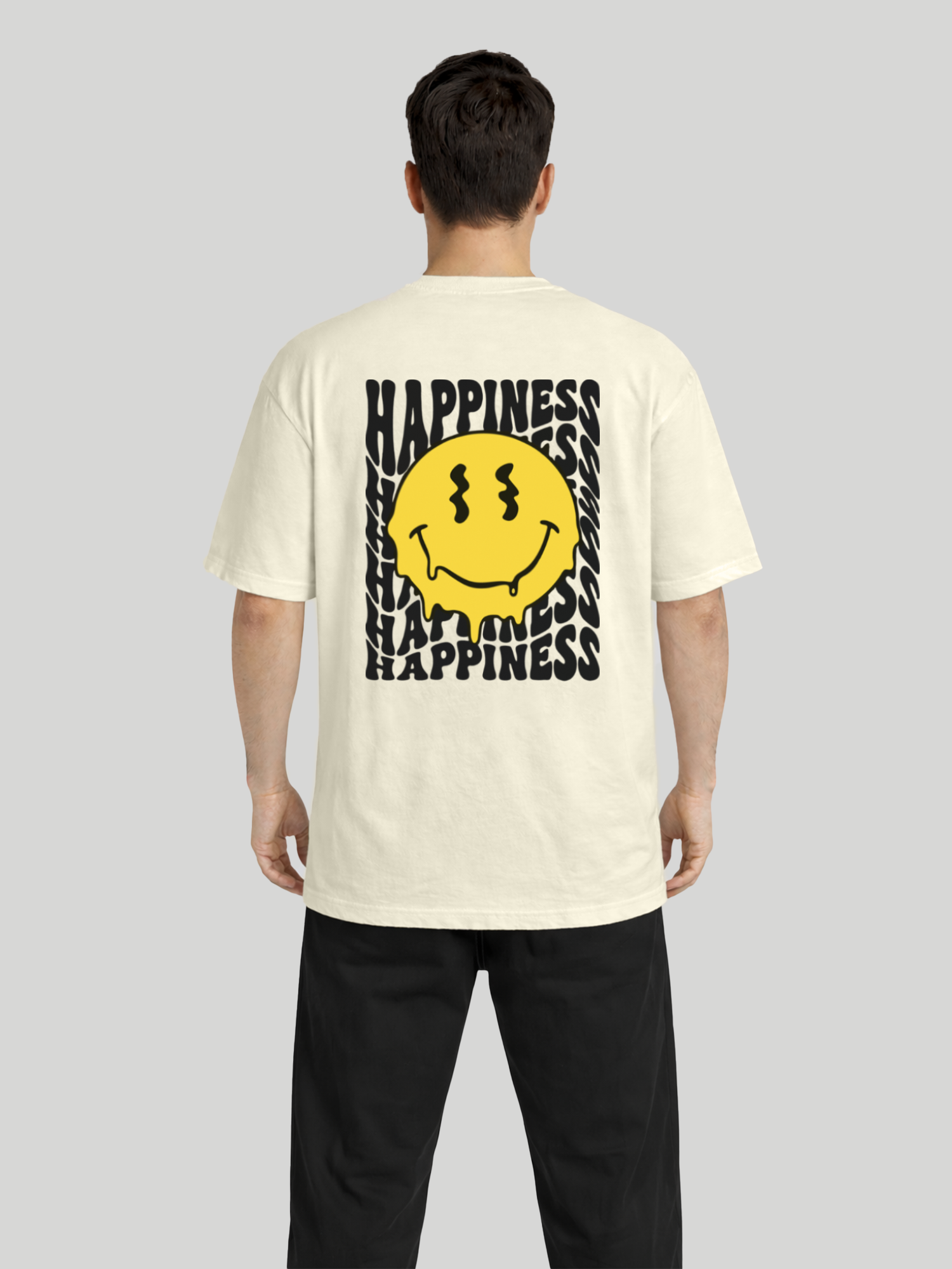 Full back view of man wearing butter oversized t-shirt with Happiness back graphic and yellow dripping smiley print