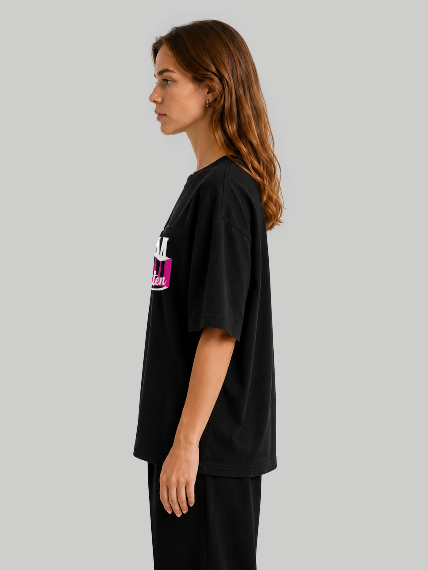 Women's oversized black t-shirt with "No Safe Path – Freedom Unwritten" print, side profile view showcasing relaxed fit.
