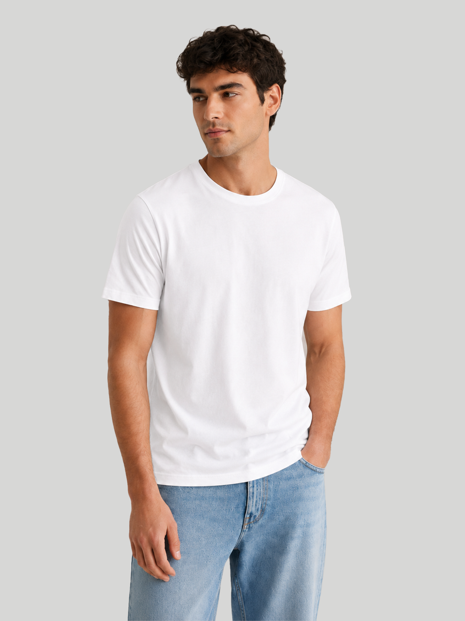 A front three-quarter pose of a male model looking to the side with one hand in his pocket, wearing a plain white premium cotton regular round neck half-sleeve t-shirt.