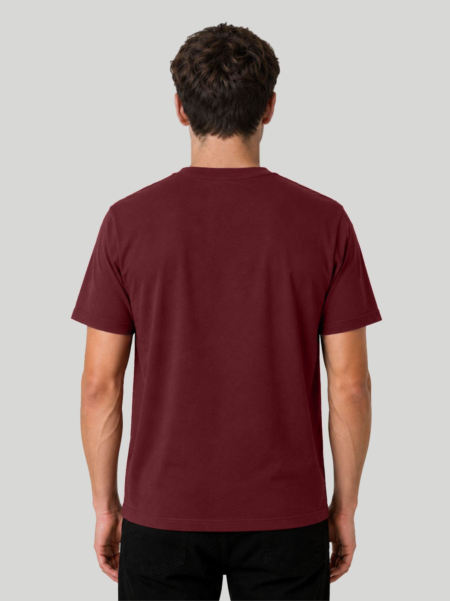 The back view of a male model wearing a solid maroon regular fit cotton t-shirt, showcasing the fabric structure and clean neckline drape.