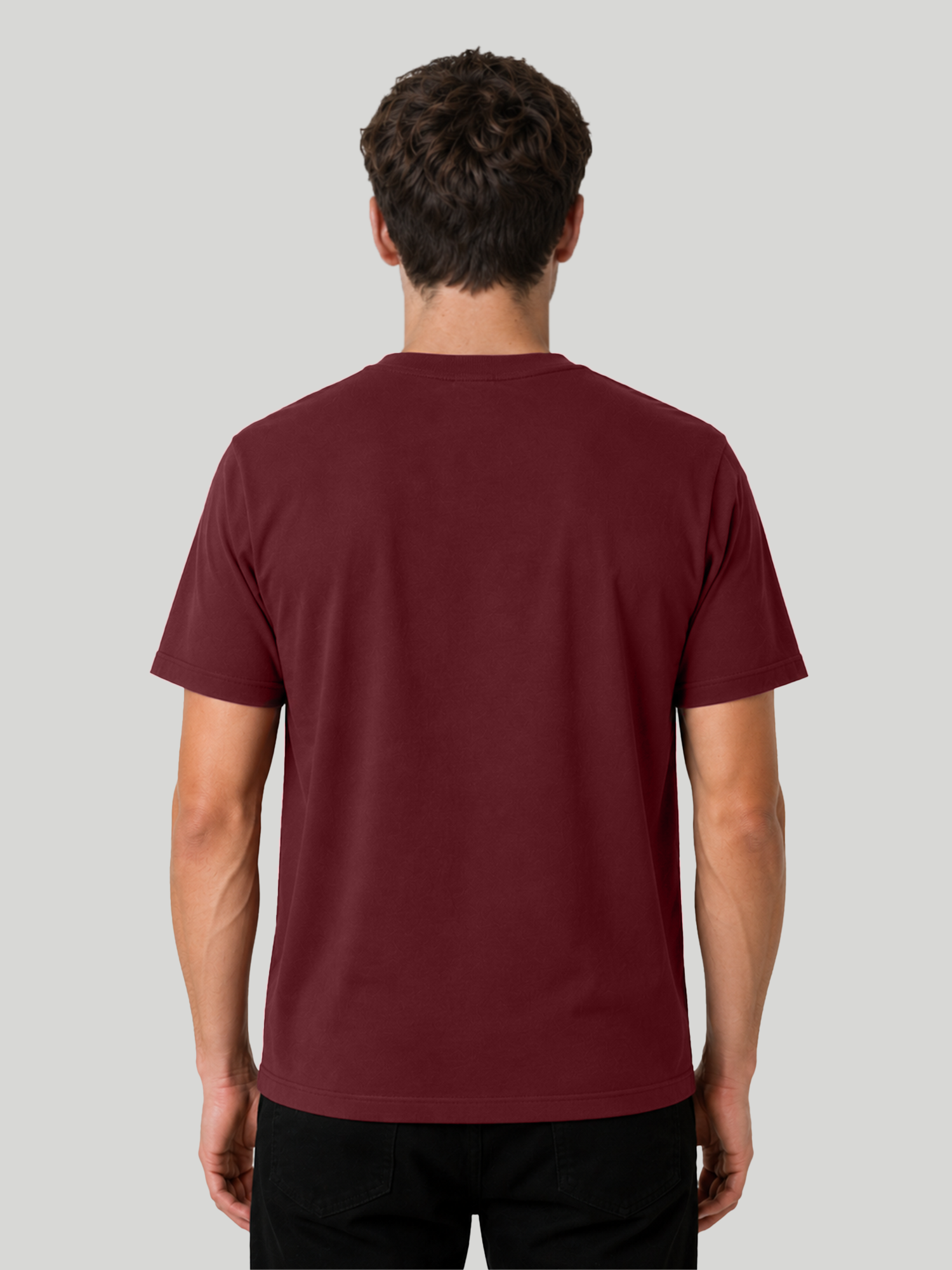 The back view of a male model wearing a solid maroon regular fit cotton t-shirt, showcasing the fabric structure and clean neckline drape.