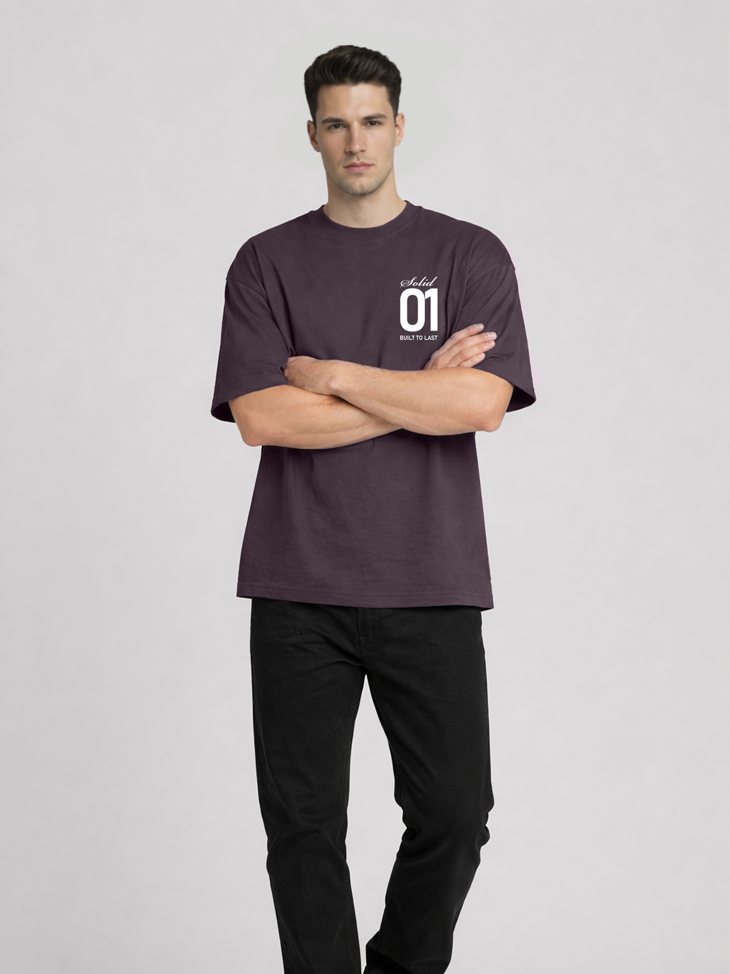 Full body view of man wearing plum oversized t-shirt with Solid 01 chest print and arms crossed