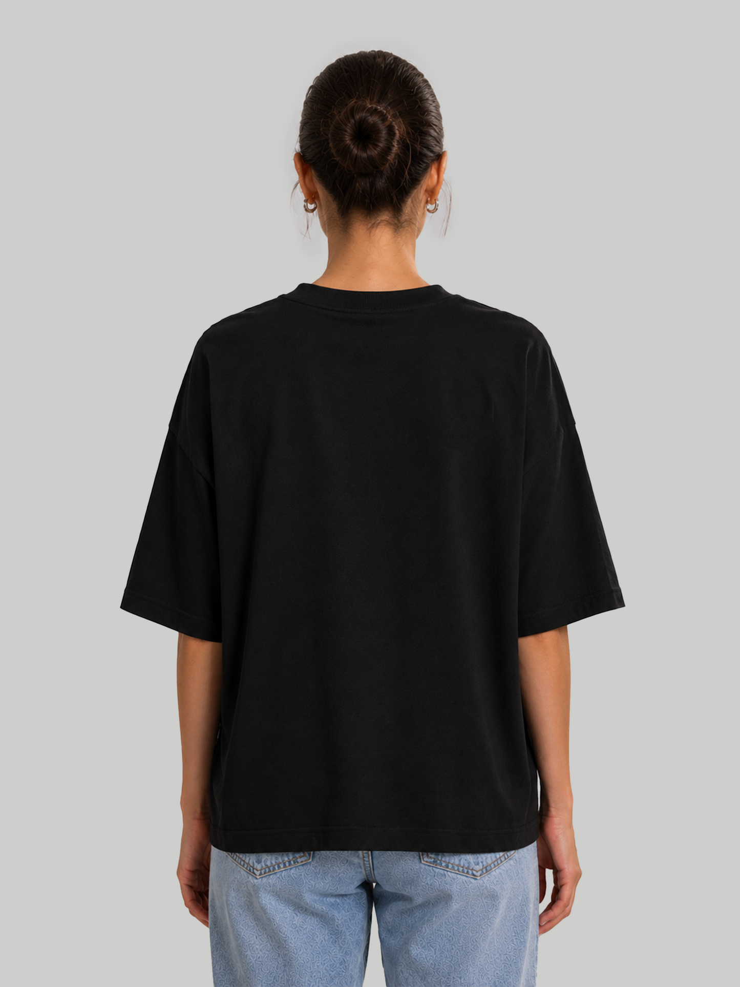 Back view of women's oversized black t-shirt on model.