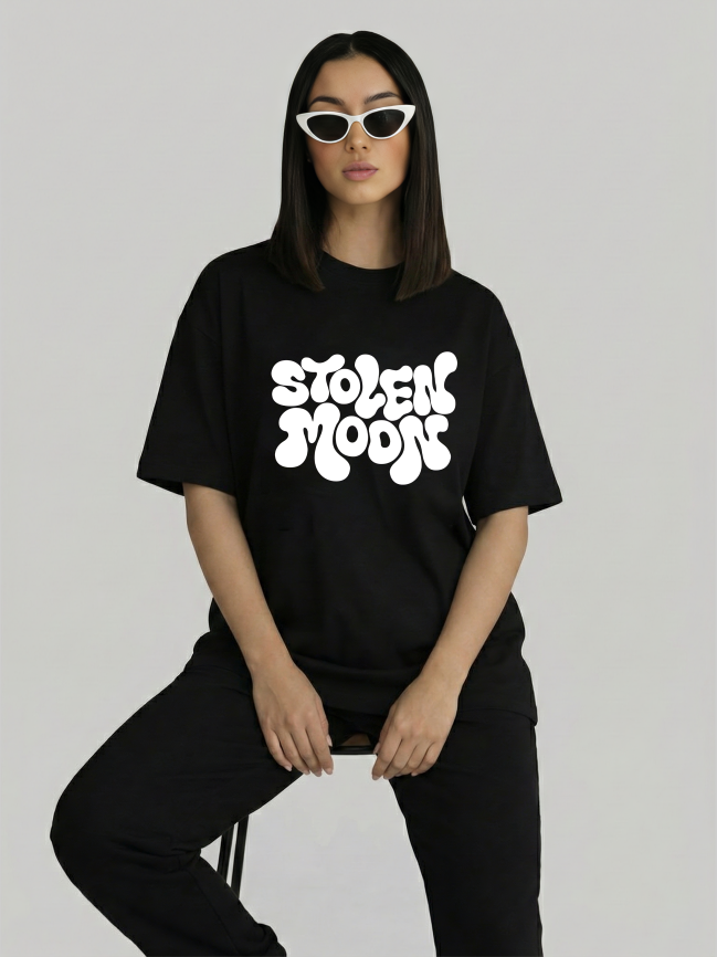 Model wearing black oversized Stolen Moods graphic t-shirt for women sitting pose