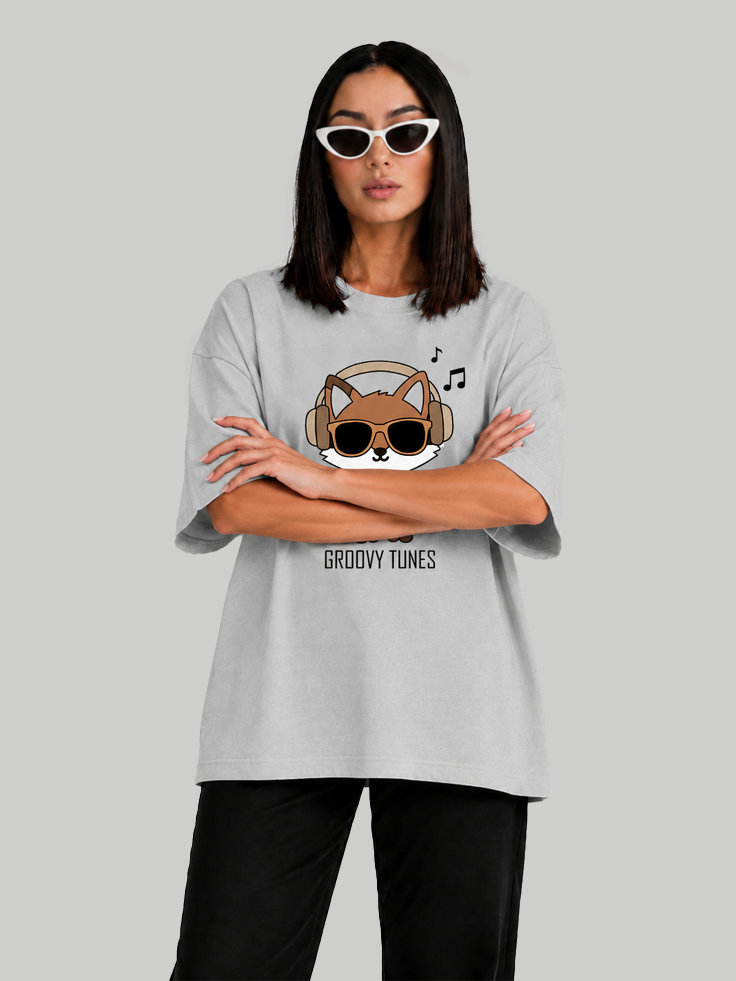 Women's oversized ash grey graphic t-shirt with Groovy Tunes fox print, front-facing pose with arms crossed.