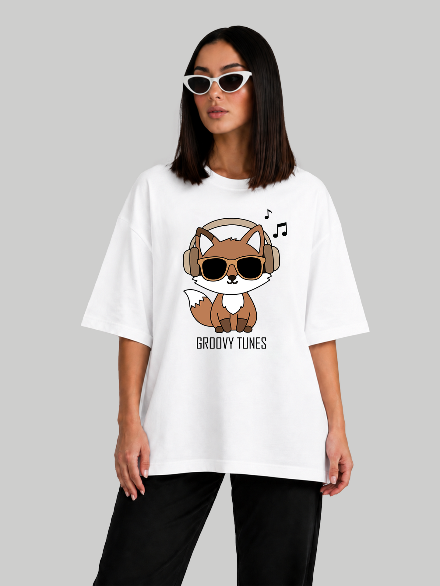 Women's oversized white Groovy Tunes t-shirt featuring a fox wearing headphones and sunglasses, angled front view.