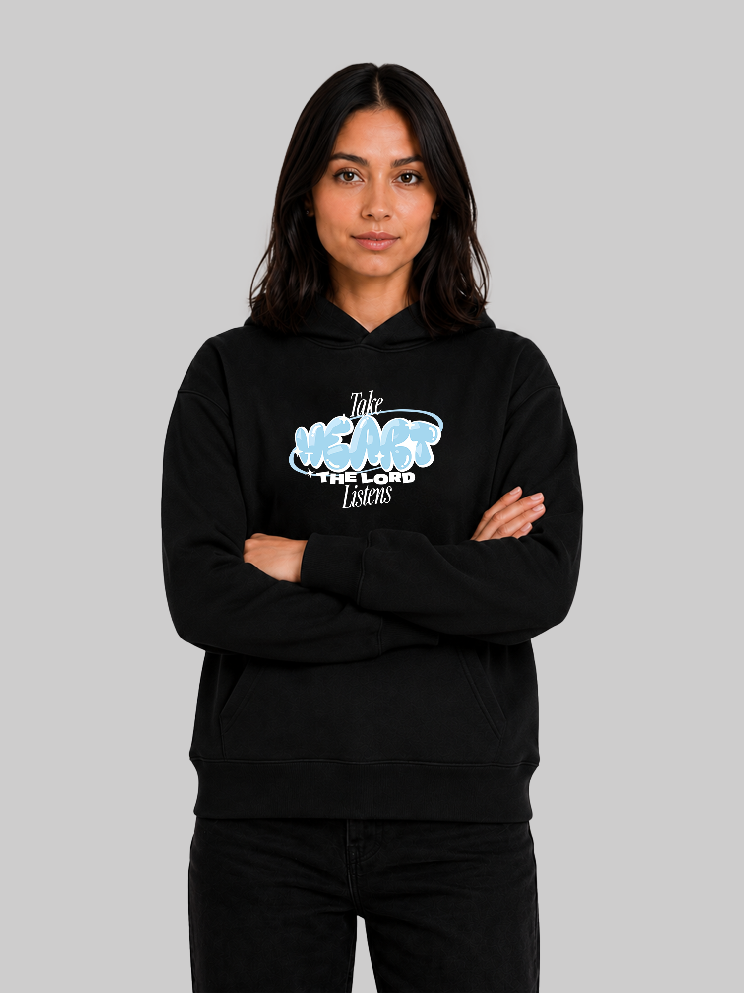 Black women's Christian graphic hoodie with "Take Heart The Lord Listens" print and crossed arms pose