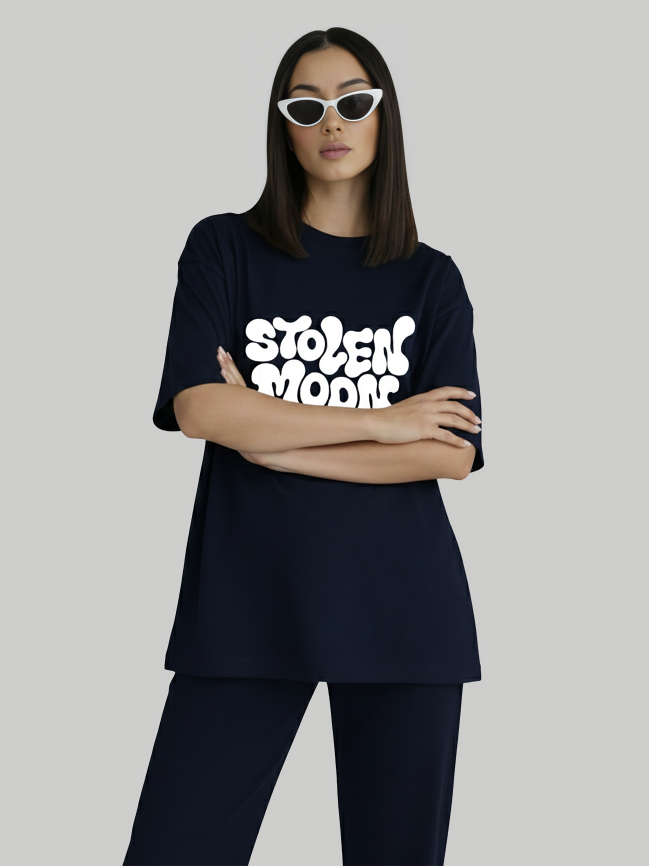 Model wearing navy blue oversized Stolen Moods graphic tee for women crossed arms pose