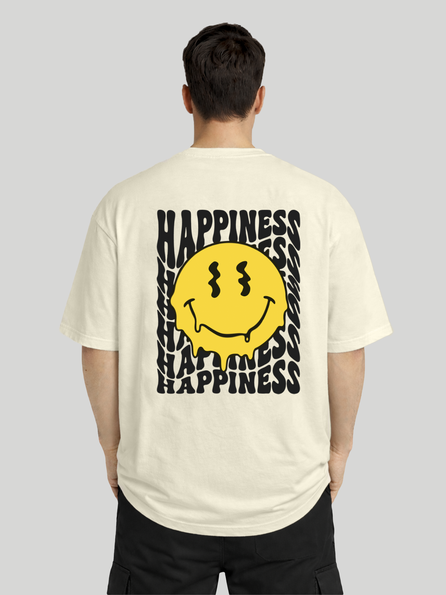 Back view of man wearing butter oversized t-shirt with Happiness back graphic and yellow dripping smiley print